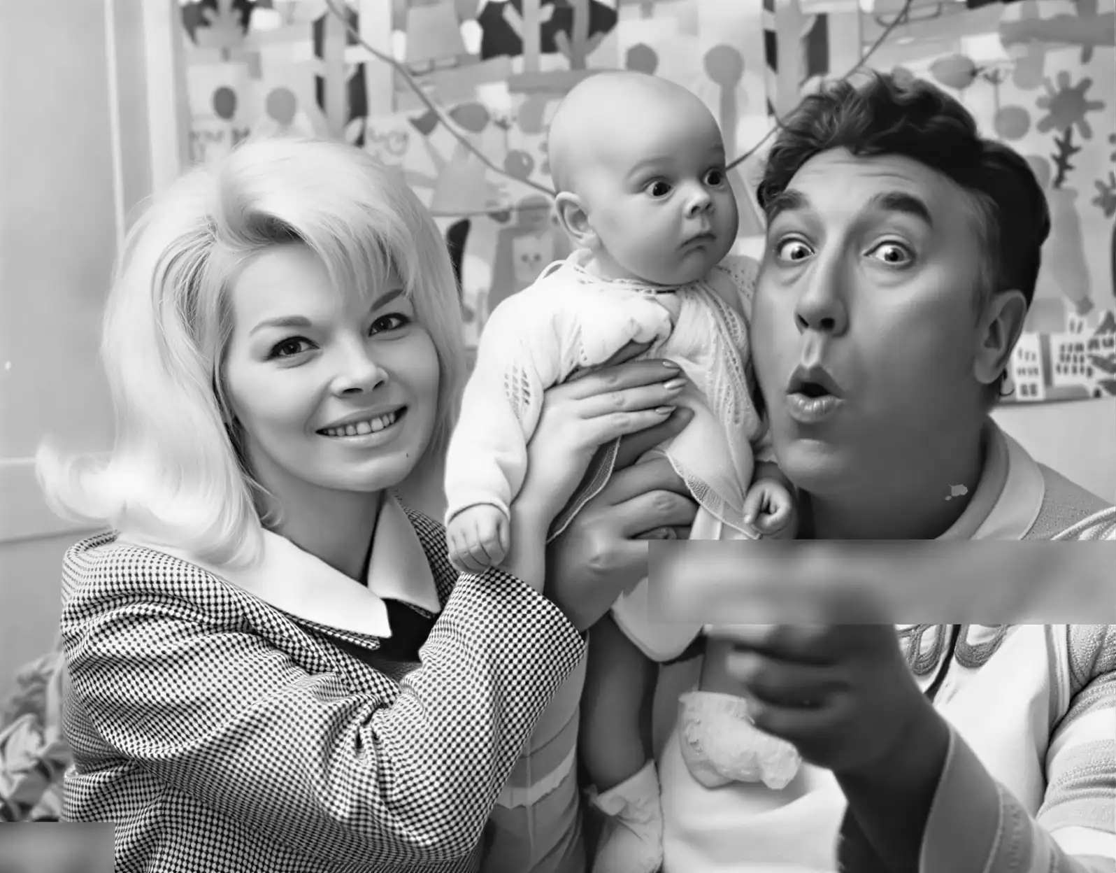 Marion Spence shows off nine week old daughter Sarah to comedian Frankie Howard.
